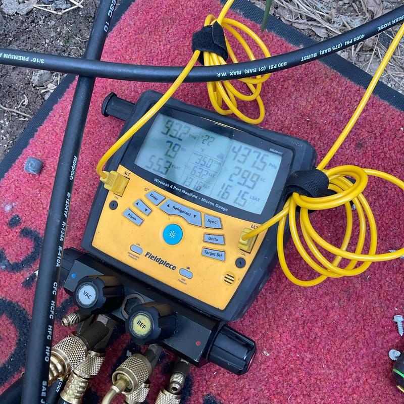 Refrigerant manifold gauge with yellow hoses on mat Refrigerant manifold gauge with yellow hoses on mat