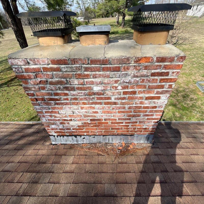 Brick chimney with cracked mortar and damaged flashing