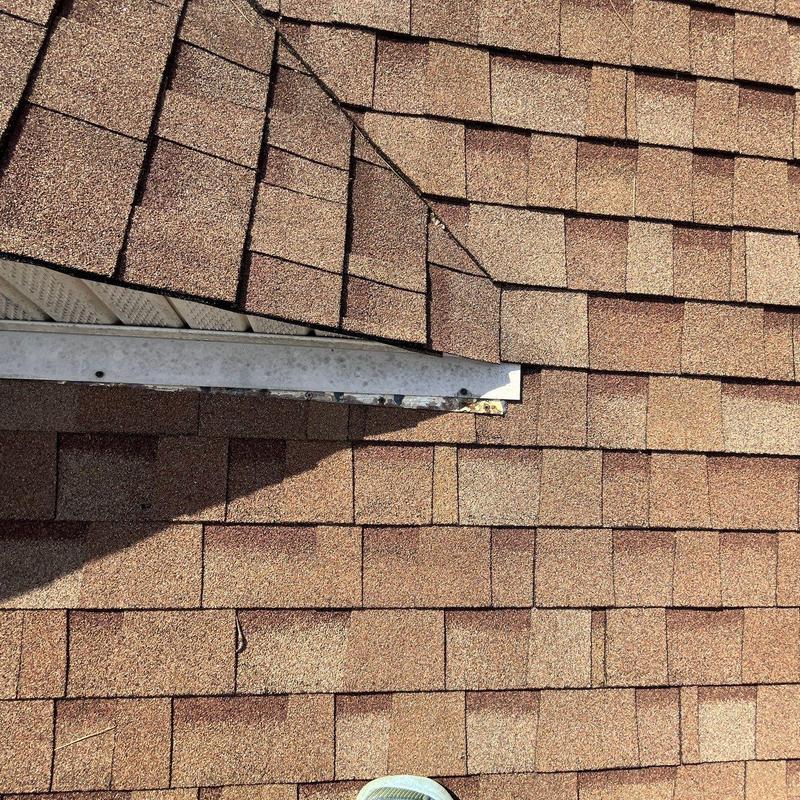 Asphalt shingles and flashing with hail damage on roof