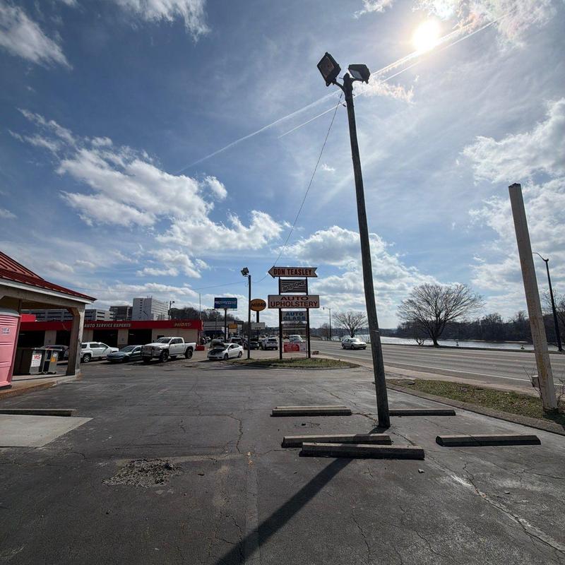 Parking lot asphalt with pothole and light pole shadow