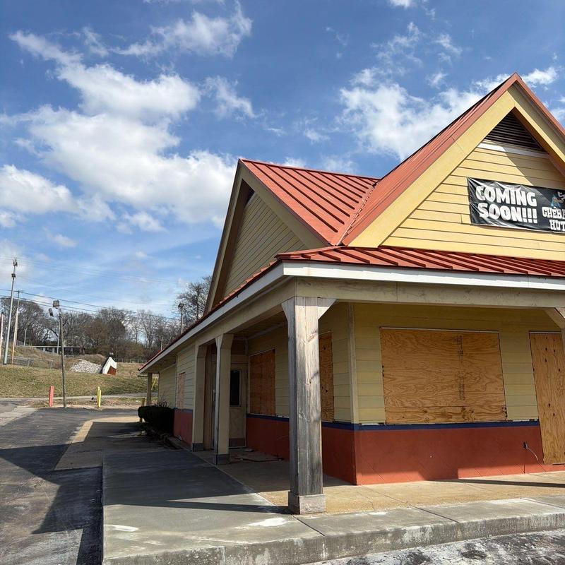 Metal roof and wooden siding with boarded windows