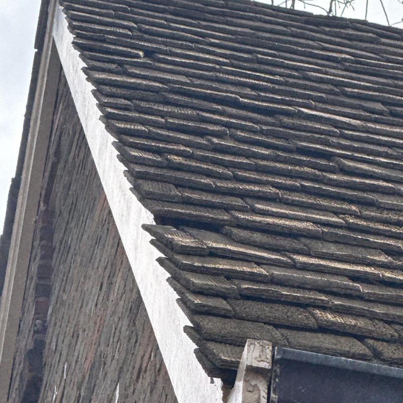 Tile roofing with hail damage on steep slope edge