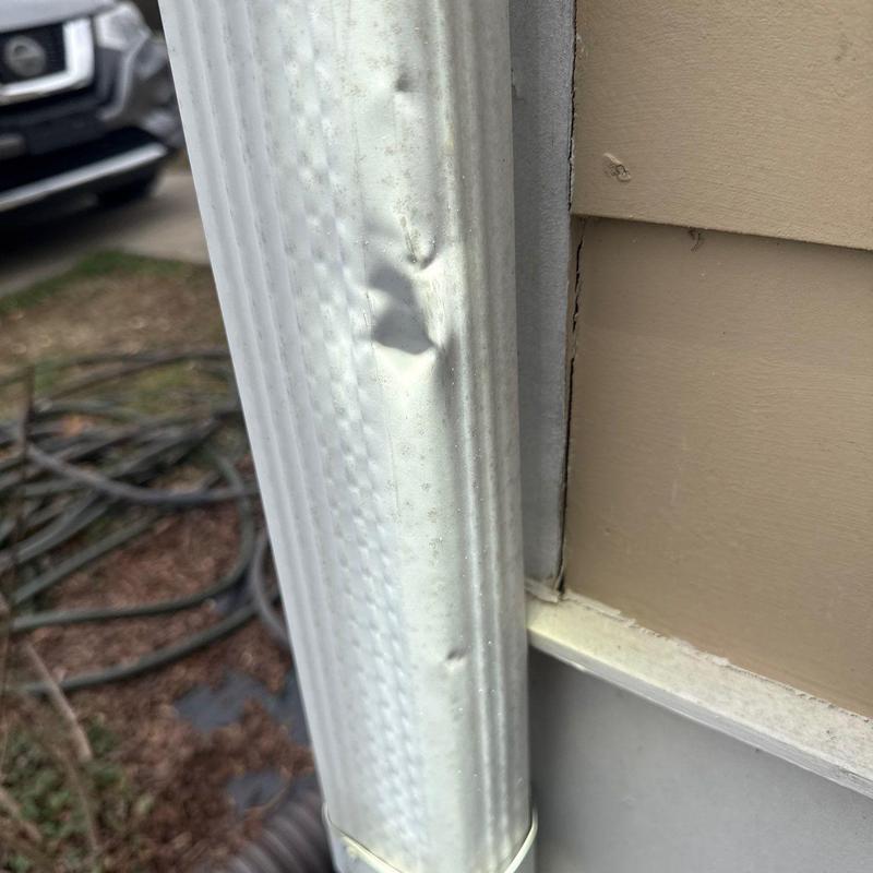 Aluminum downspout with hail damage dents