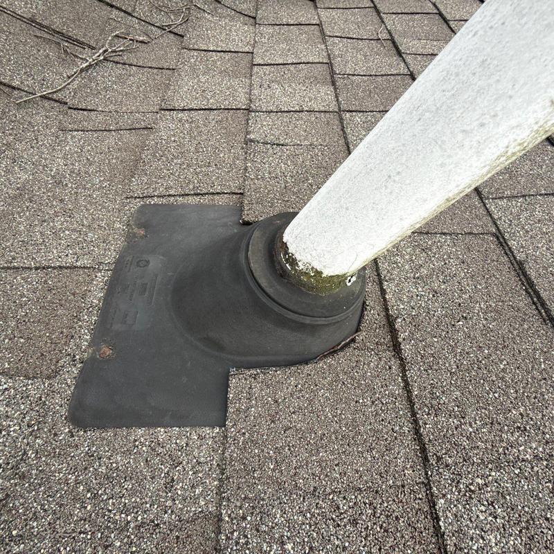 Roof pipe flashing and shingle installation on asphalt roof