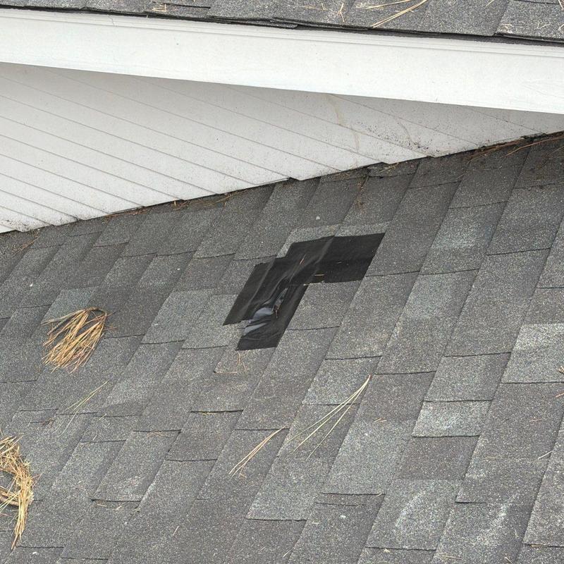Roof shingles with patch tape on asphalt roof section