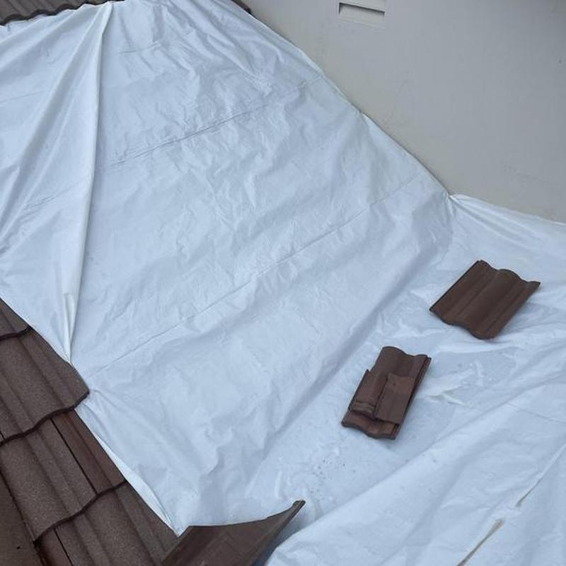 Clay tile roof with protective tarp covering repairs Clay tile roof with protective tarp covering repairs