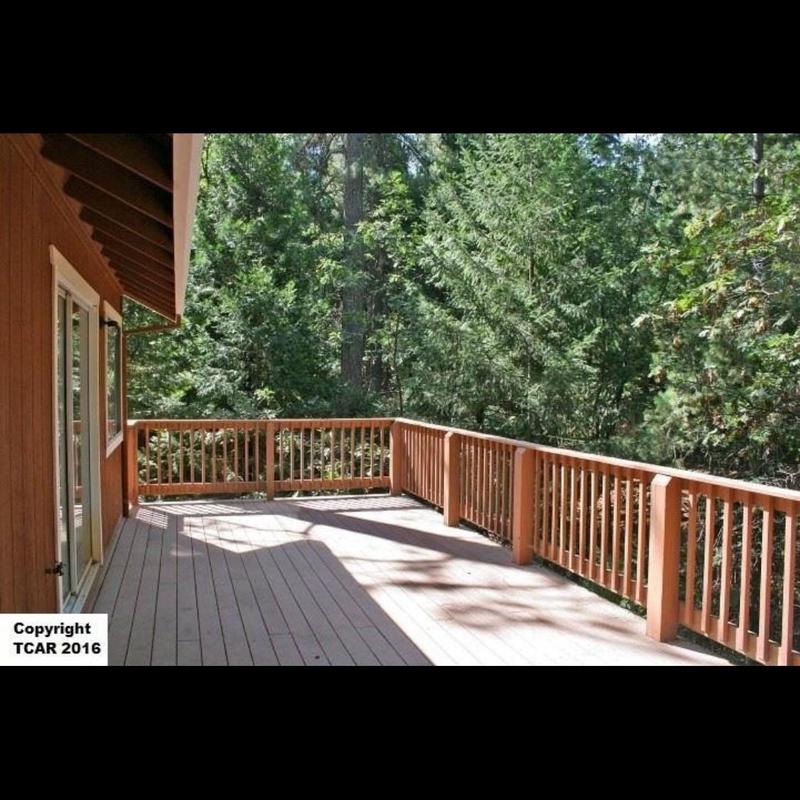 Wood deck with railing overlooking forest area Wood deck with railing overlooking forest area