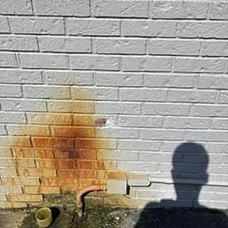 Exterior faucet removal on brick wall with rust stains