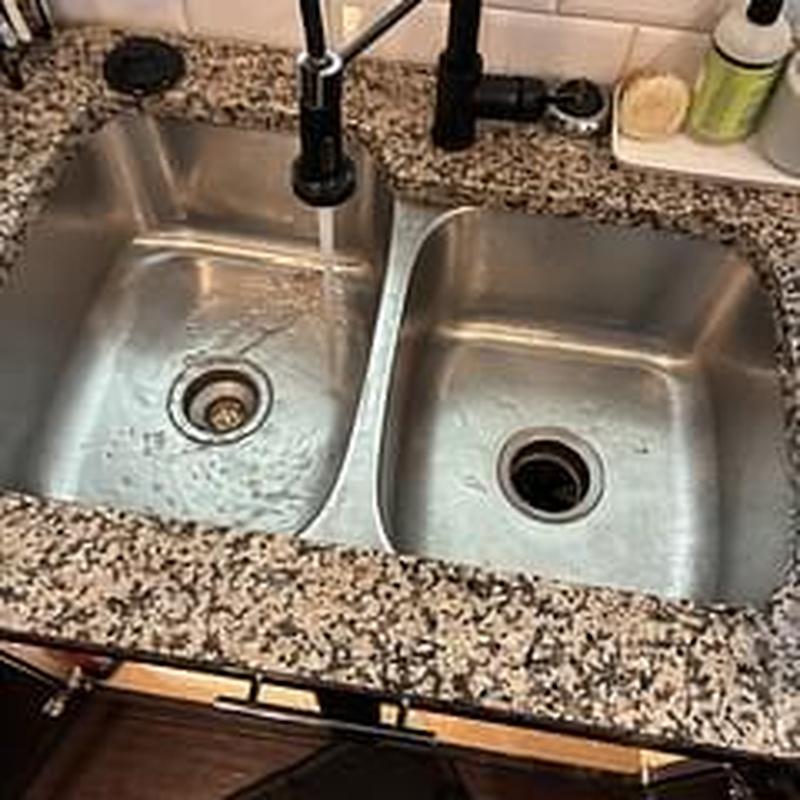Kitchen sink drain with running water and granite counter