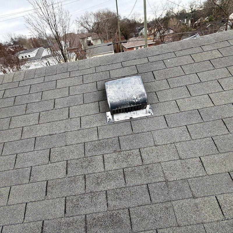 Roof shingles with metal vent on residential roof