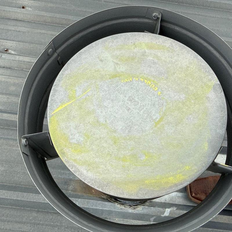 Roof vent cap with hail damage on metal roof
