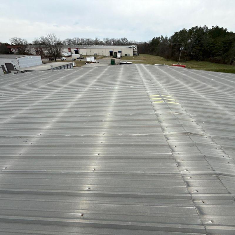 Metal commercial roof with hail damage markings