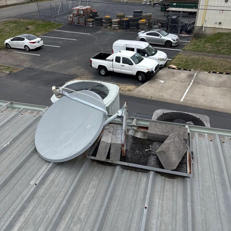 Satellite dish and rooftop HVAC unit on metal roof