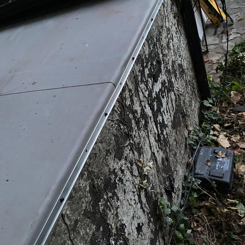 Sheet metal flashing at roof-to-wall seam installation