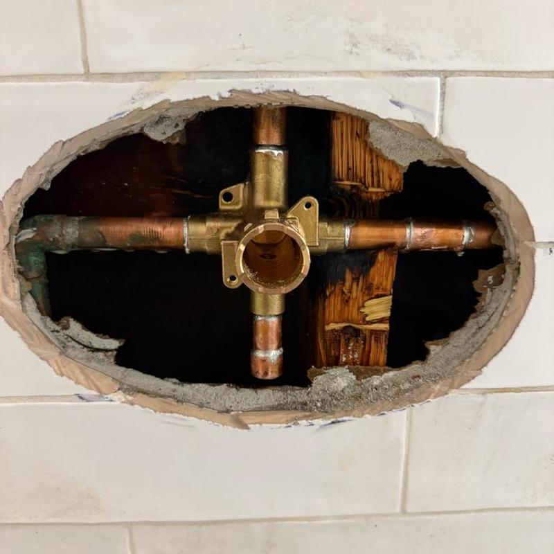 Shower valve plumbing behind tiled wall cutout