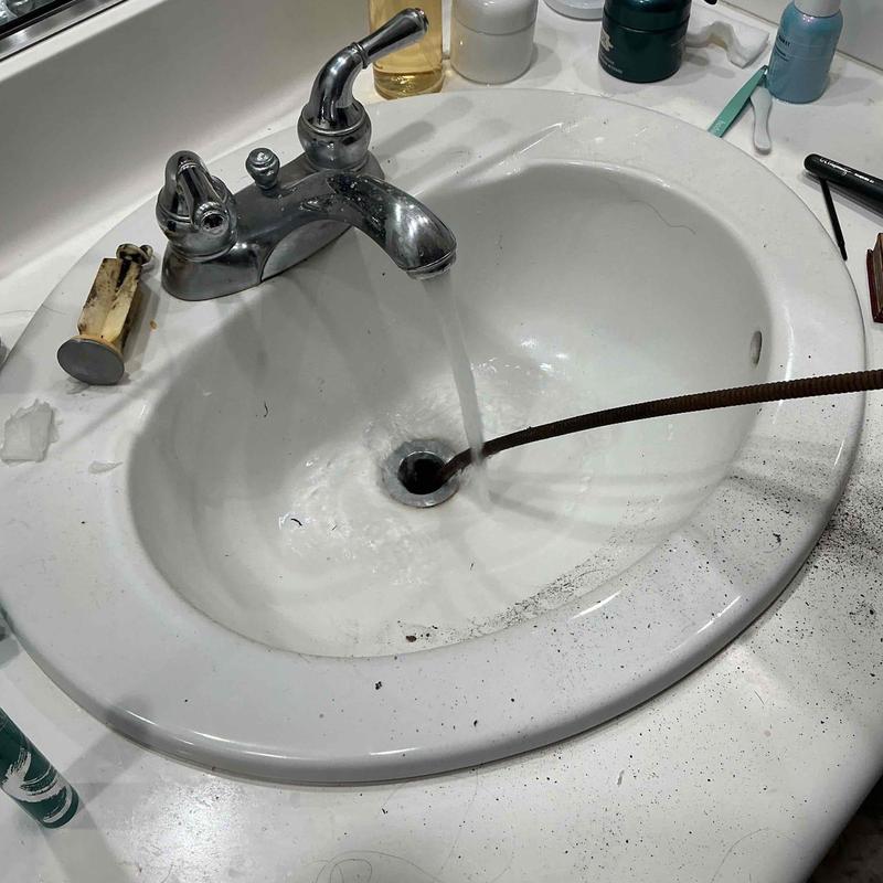 Sink drain clog cleaning with plumbing snake