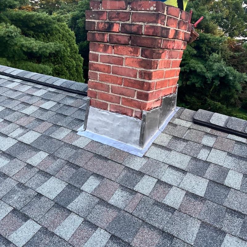Chimney metal flashing on asphalt shingle roof Chimney metal flashing on asphalt shingle roof