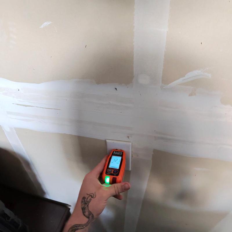 Electrical outlet voltage tester in use on wall Electrical outlet voltage tester in use on wall