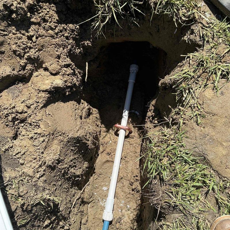 Polybutylene water main exposed in soil trench