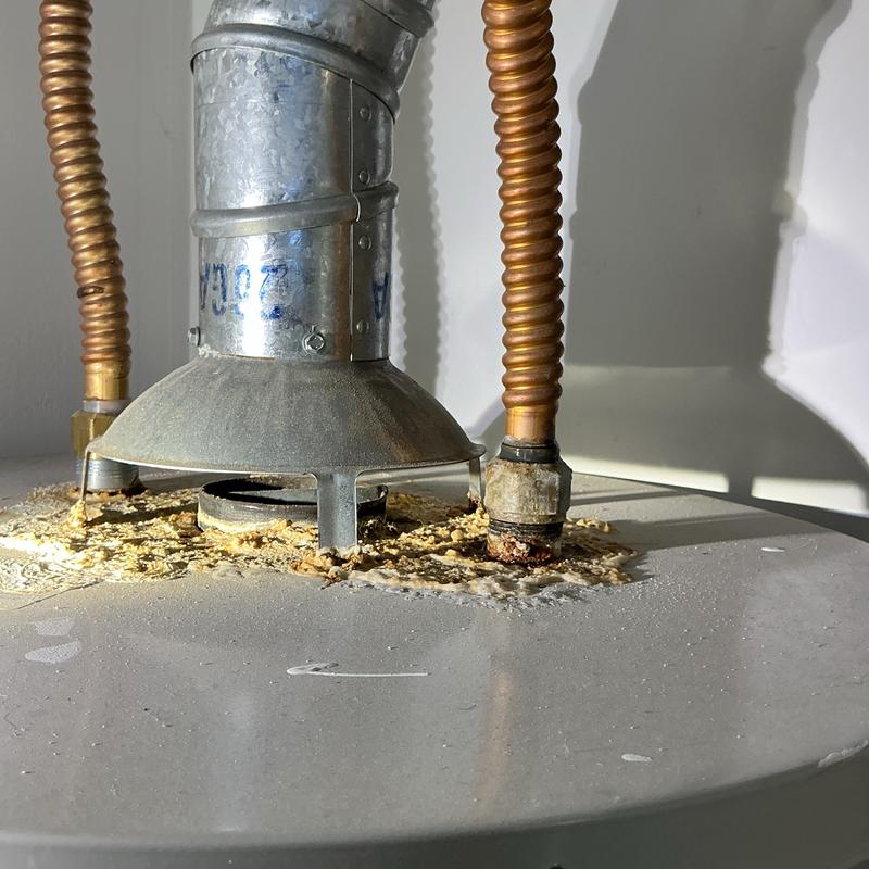 Gas water heater top with corrosion and rust buildup Gas water heater top with corrosion and rust buildup