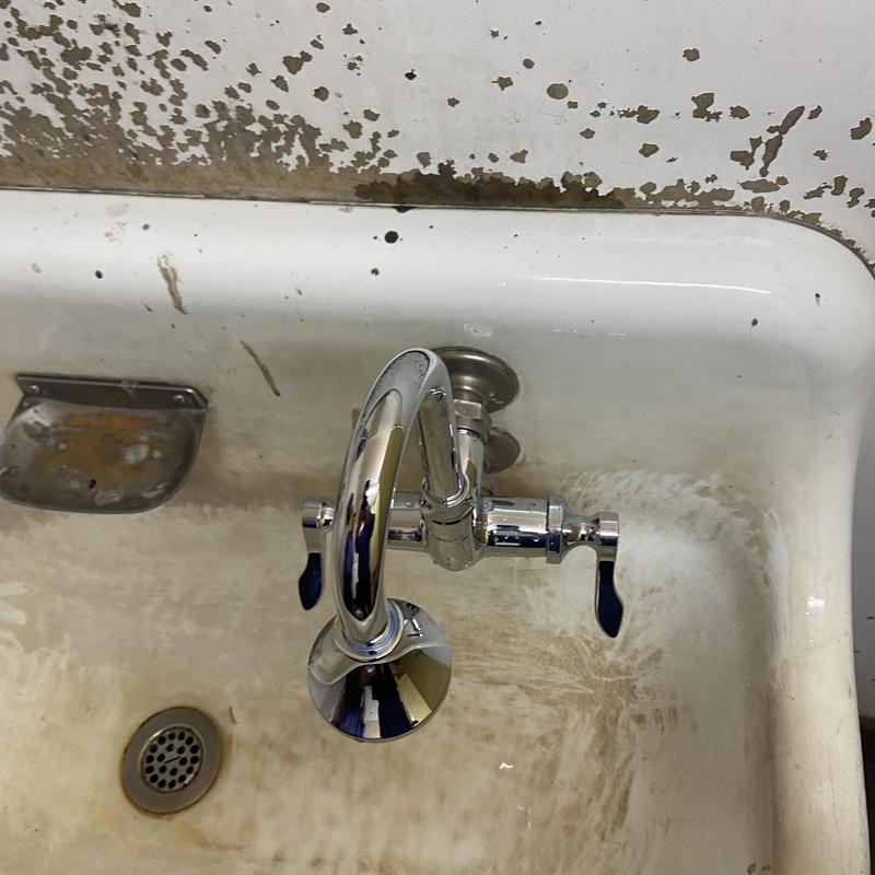 Commercial faucet with dual handles in stained sink Commercial faucet with dual handles in stained sink