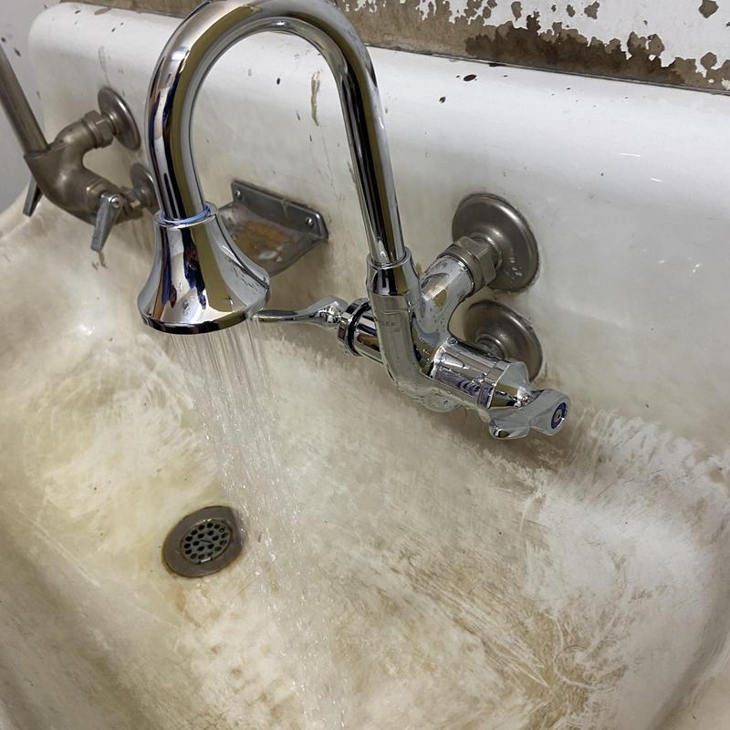 Commercial faucet with running water in utility sink Commercial faucet with running water in utility sink
