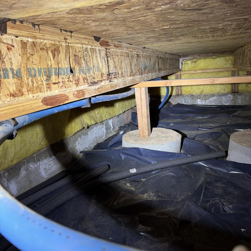 PEX water piping installation in crawl space with support beams