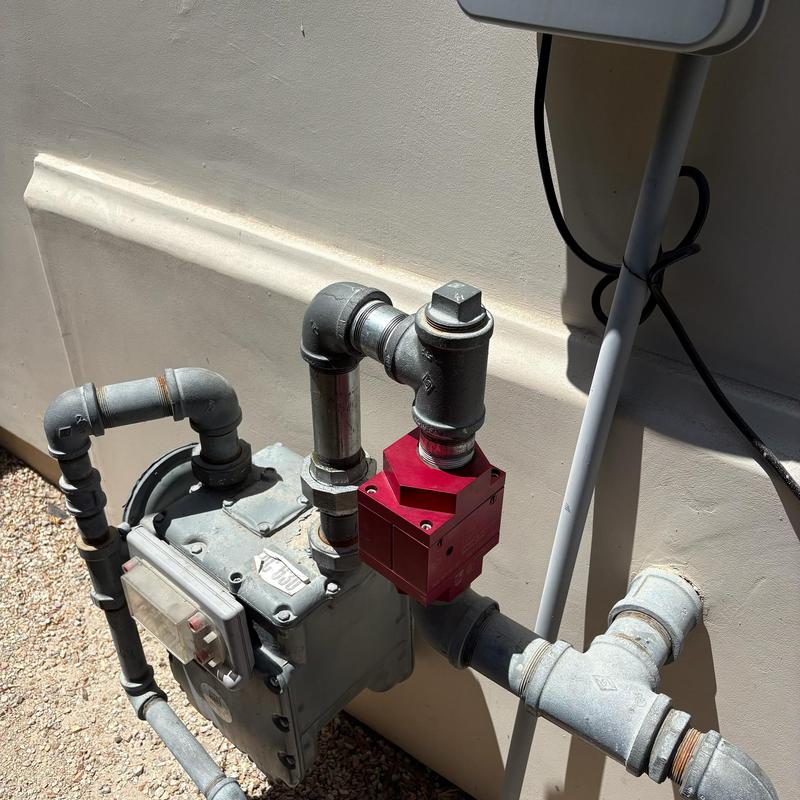 Gas shutoff valve with red safety device on piping Gas shutoff valve with red safety device on piping