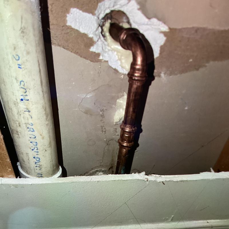 Copper supply line inside wall behind vanity