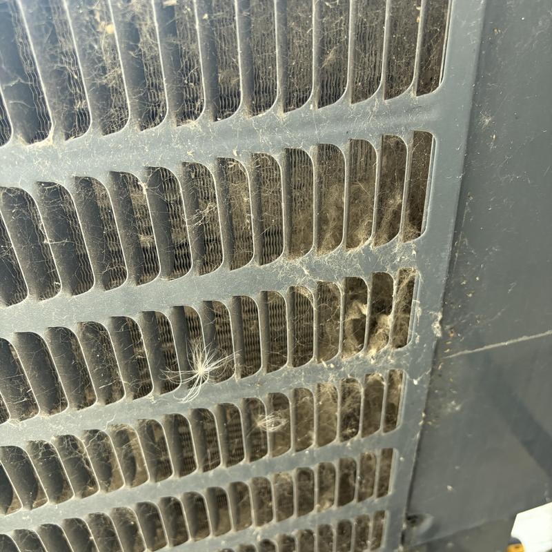Outdoor heat pump condenser coil clogged with dust and debris Outdoor heat pump condenser coil clogged with dust and debris
