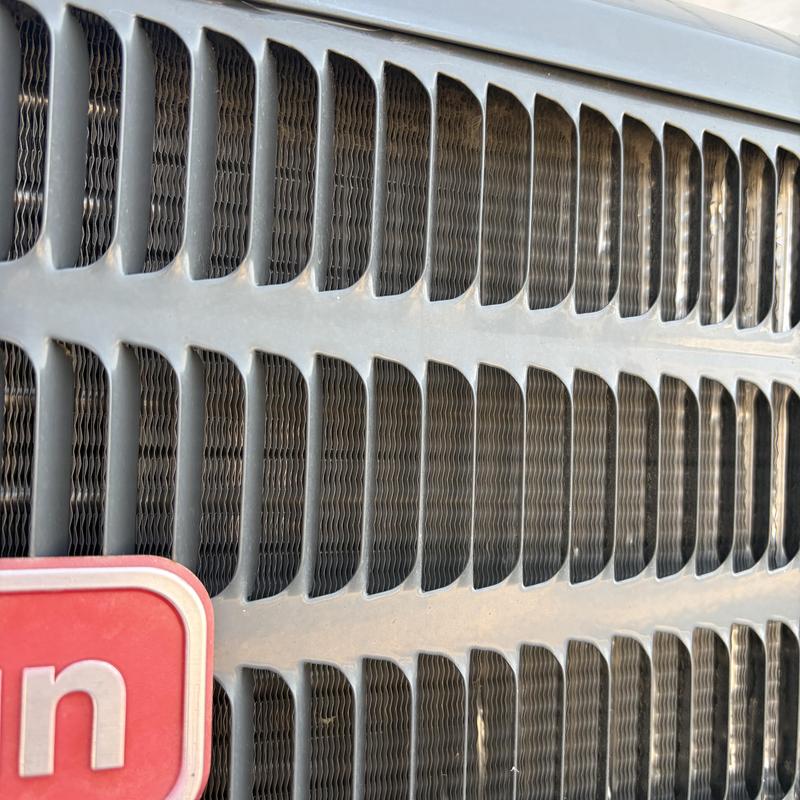 Heat pump condenser coil close-up with protective grille Heat pump condenser coil close-up with protective grille