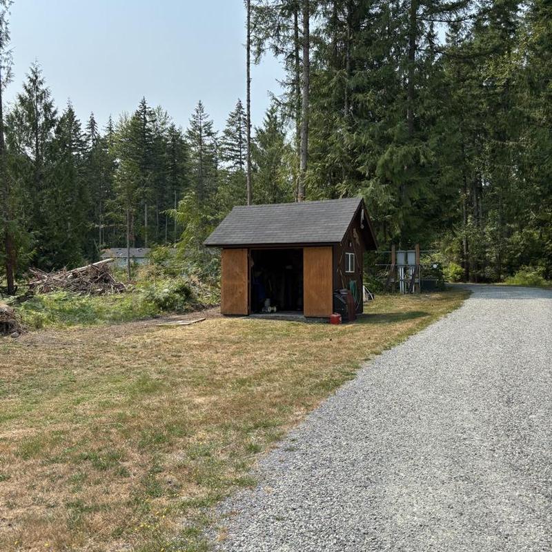 Pump house roof with brown shingle and wooden doors Pump house roof with brown shingle and wooden doors