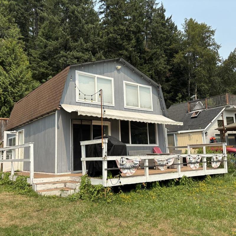 Brown shingle roof on blue cabin with deck Brown shingle roof on blue cabin with deck