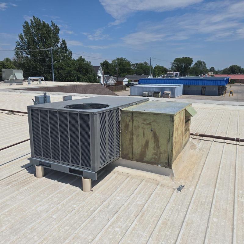 Commercial rooftop HVAC unit on metal roof Commercial rooftop HVAC unit on metal roof