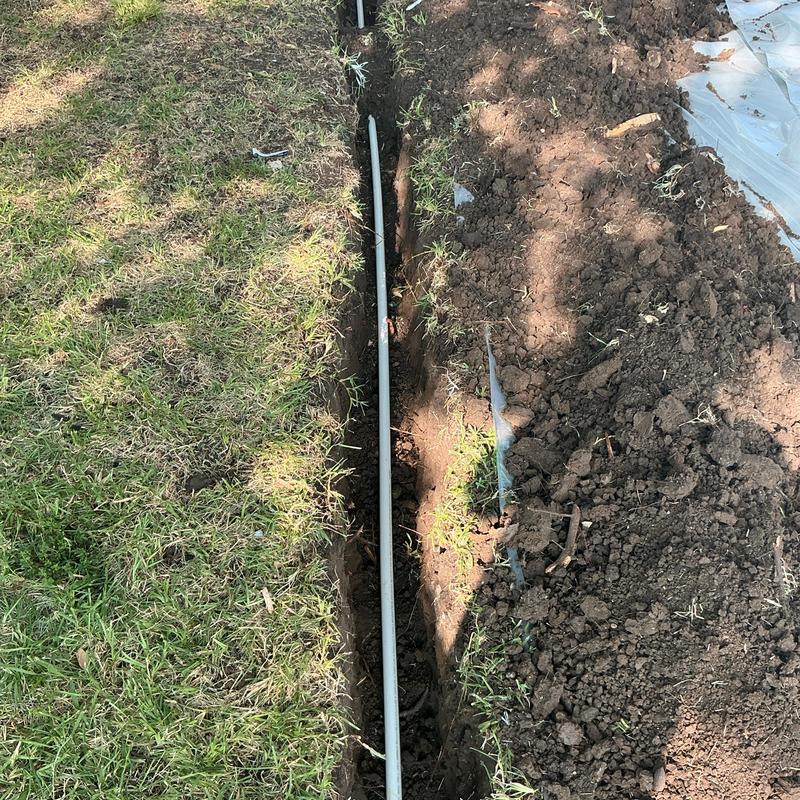 Pex water service pipe laid in trench in yard