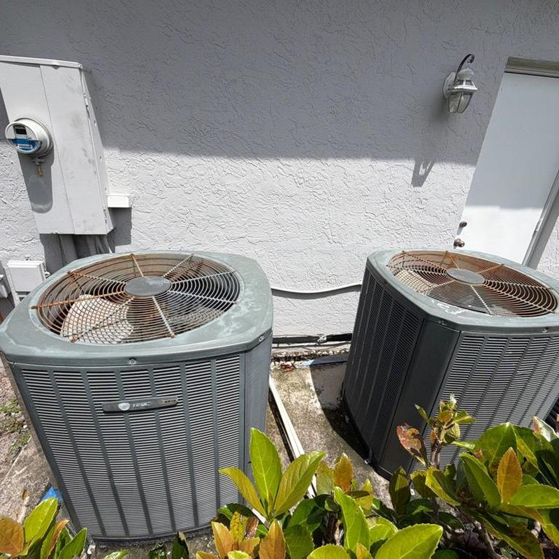 Dual Trane outdoor AC condensers with rusted fan guards Dual Trane outdoor AC condensers with rusted fan guards