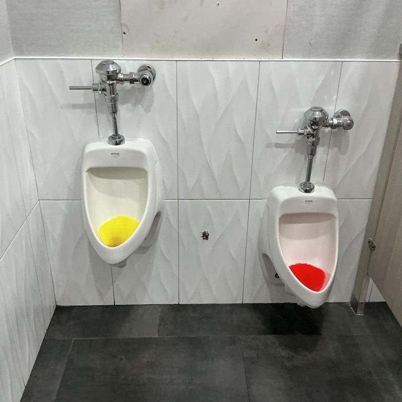 Urinal flush valves in public restroom corner Urinal flush valves in public restroom corner