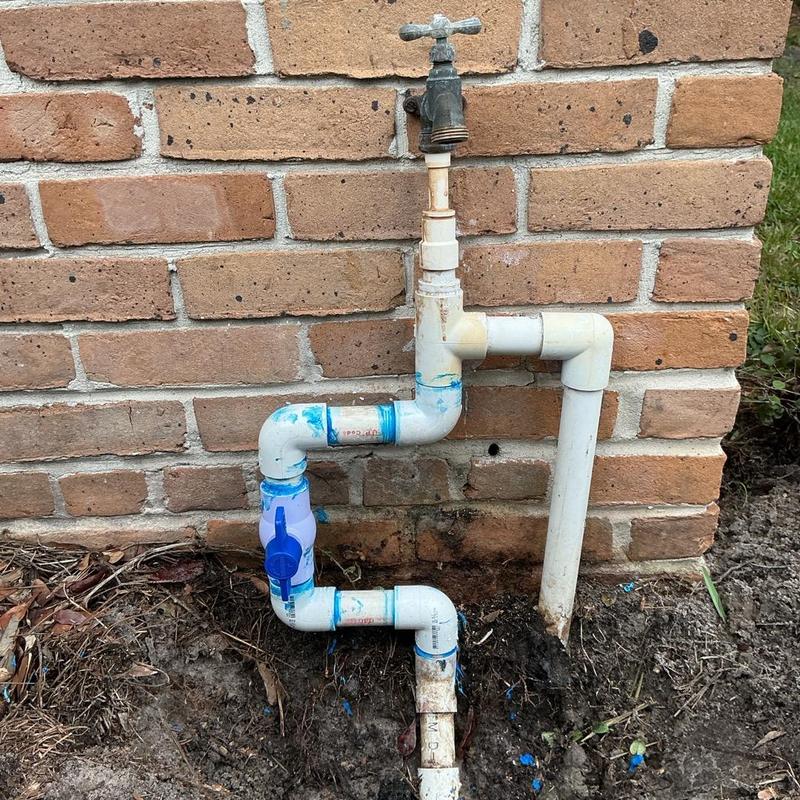 PVC water line with ball valve installed near brick wall PVC water line with ball valve installed near brick wall