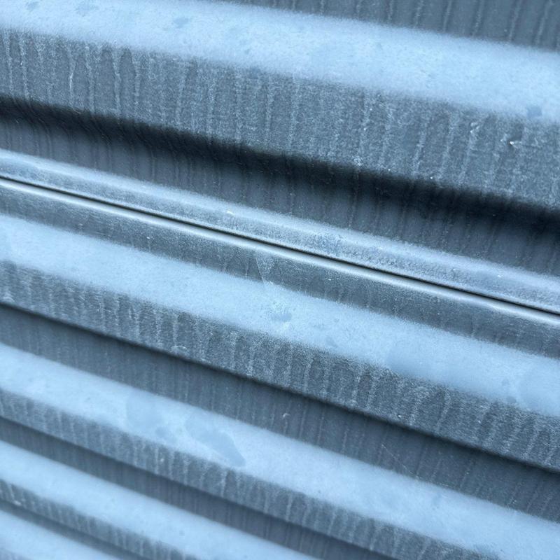 Metal roof panel with hail damage close-up