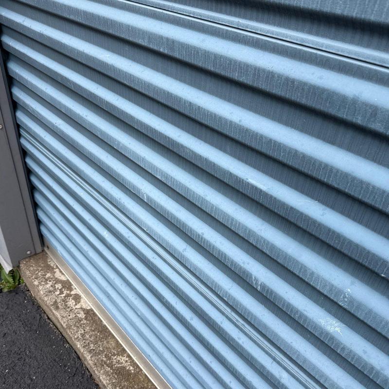 Metal rolling door with weather stripping at base