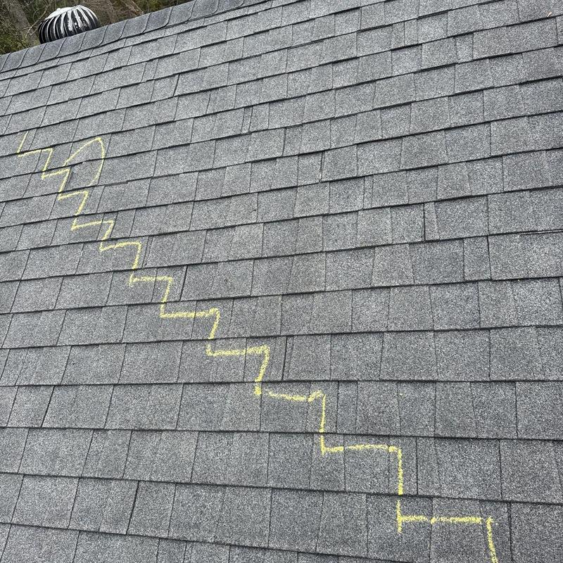 Asphalt shingle roof with hail damage marked in chalk