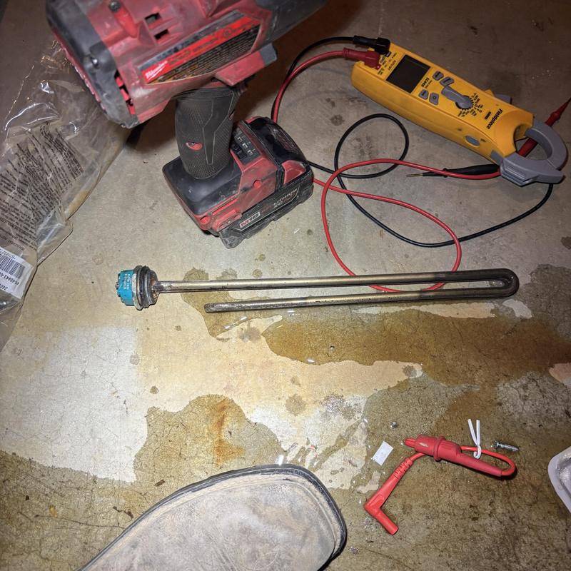 Water heater heating element with testing tools on floor Water heater heating element with testing tools on floor
