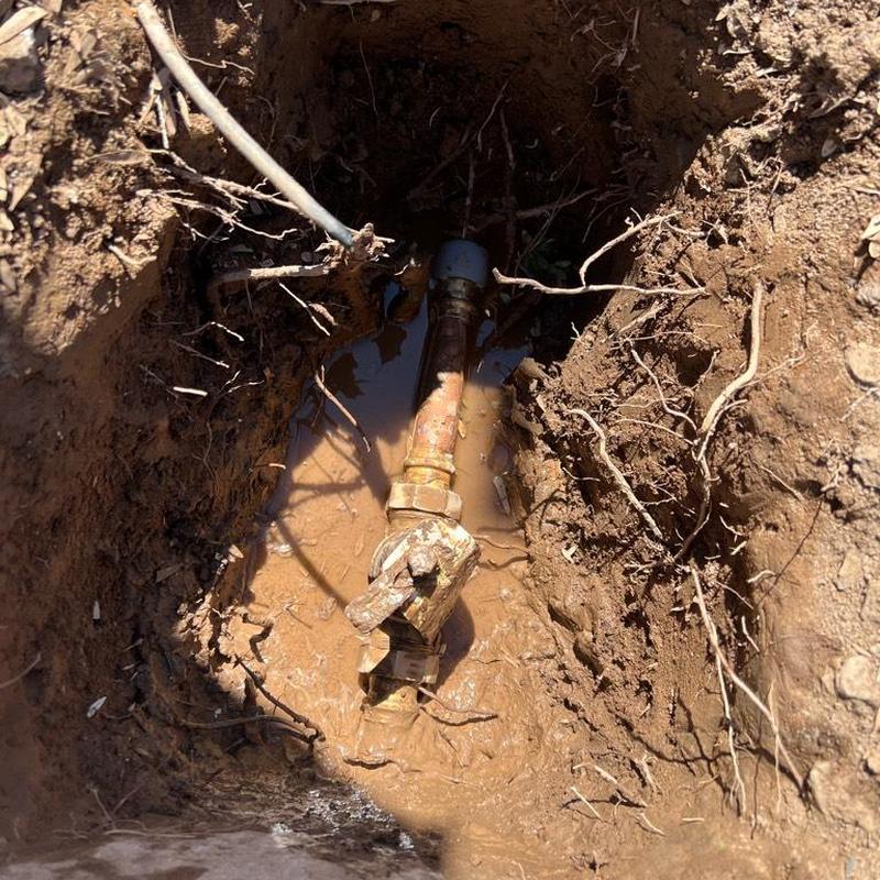 Main waterline valve exposed in muddy excavation hole Main waterline valve exposed in muddy excavation hole