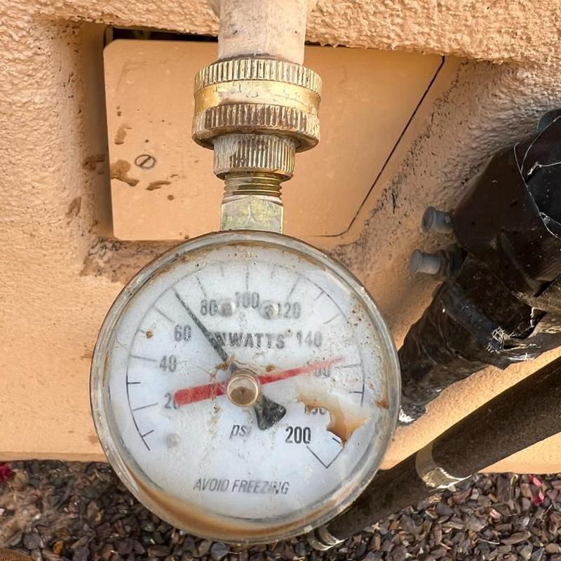 Pressure regulator valve gauge showing 68 PSI in outdoor plumbing Pressure regulator valve gauge showing 68 PSI in outdoor plumbing