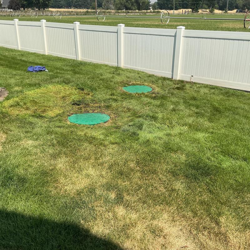 Septic system riser lids installed in backyard lawn Septic system riser lids installed in backyard lawn