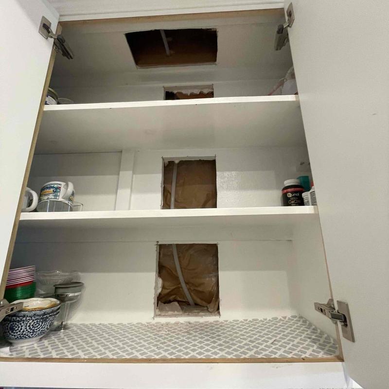Kitchen cabinet with plumbing access holes
