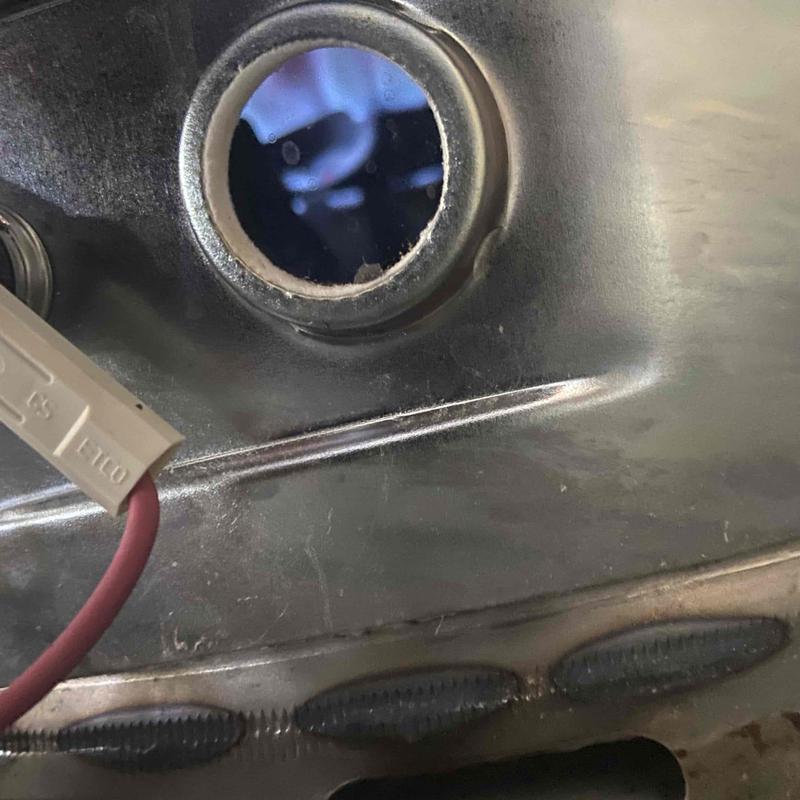 Water heater pilot assembly with flame visible inside Water heater pilot assembly with flame visible inside