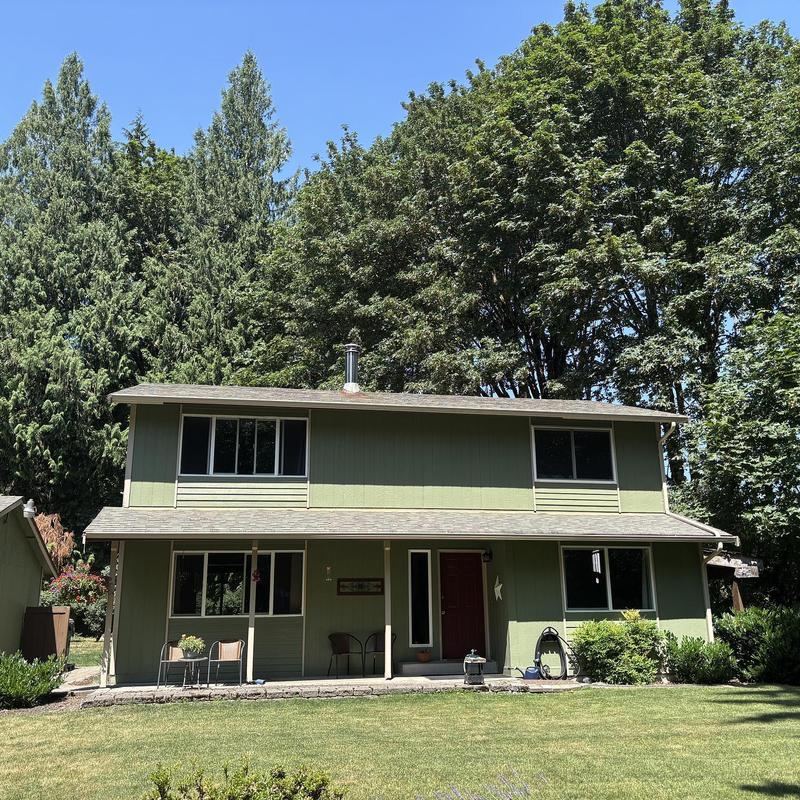 Asphalt shingle roof on green two-story home for sale Asphalt shingle roof on green two-story home for sale