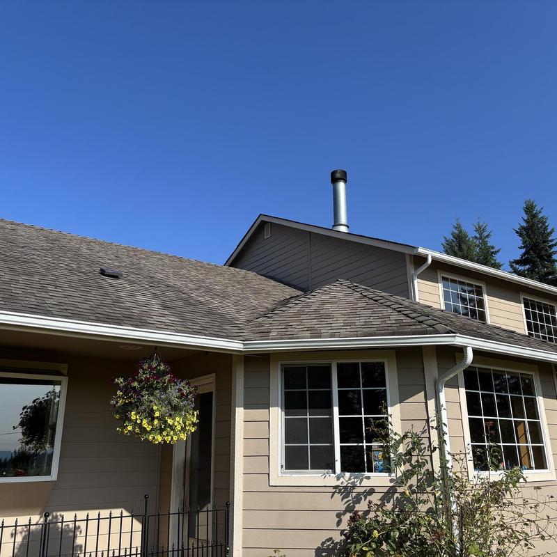 Asphalt shingle roof on beige residential home under clear sky Asphalt shingle roof on beige residential home under clear sky
