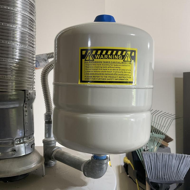 Expansion tank with warning label on water heater system Expansion tank with warning label on water heater system